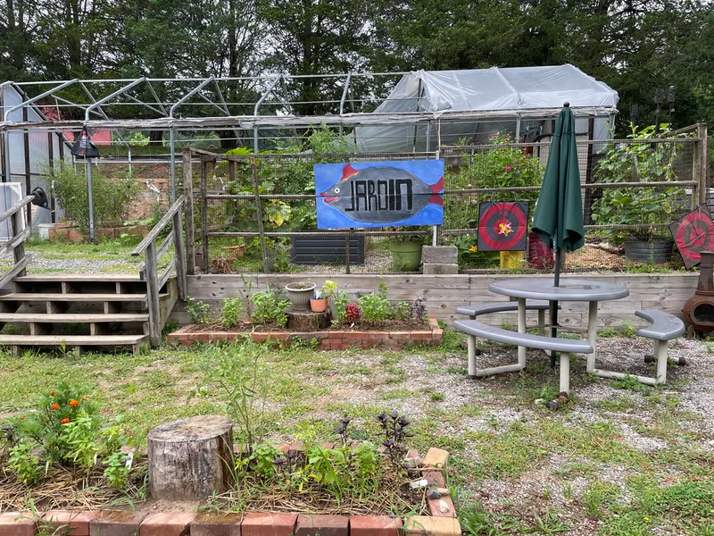 a fenced garden with a sign that reads “JARDIN”