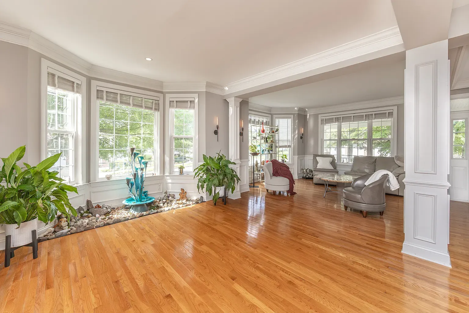 a large living and dining area with lots of windows and very little furniture on wood floors
