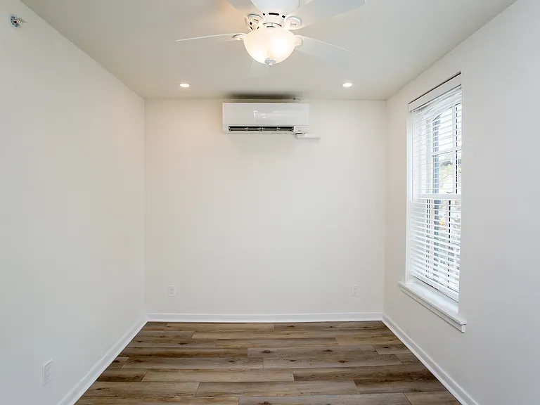 a small room with a window and an air conditioning unit mounted on the wall