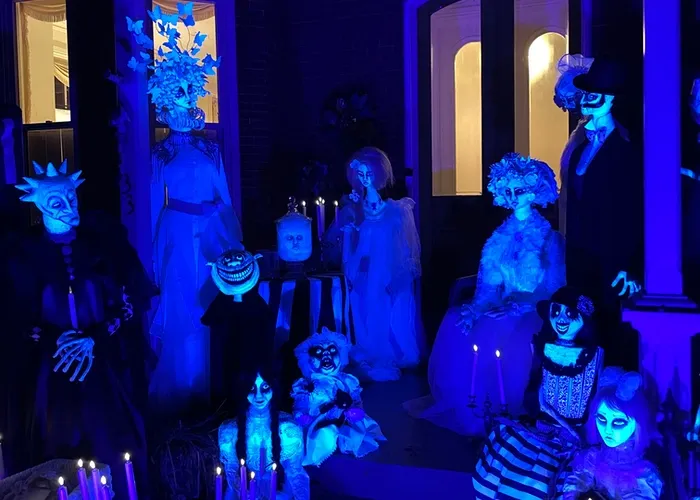 glowing haunted figures on the front steps of an old brick house