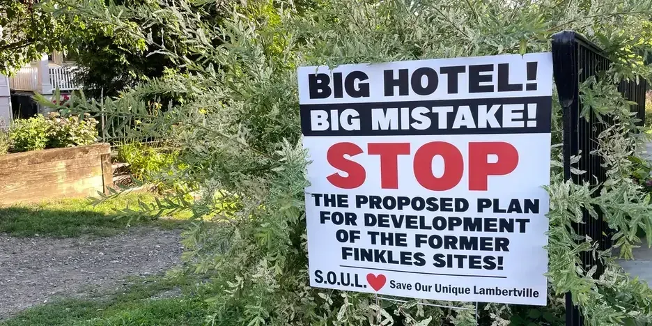 a lawn sign that reads, "Big hotel! Big Mistake! STOP the proposed plan for redevelopment of the former Finkles sites!"
