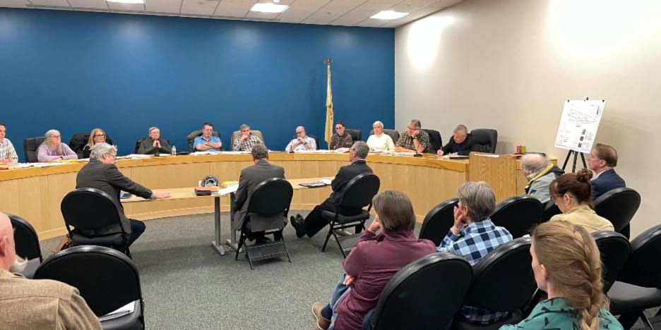 people listening to deliberations at the zoning board meeting