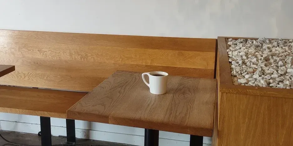 a single coffee cup sits on a table in a cafe