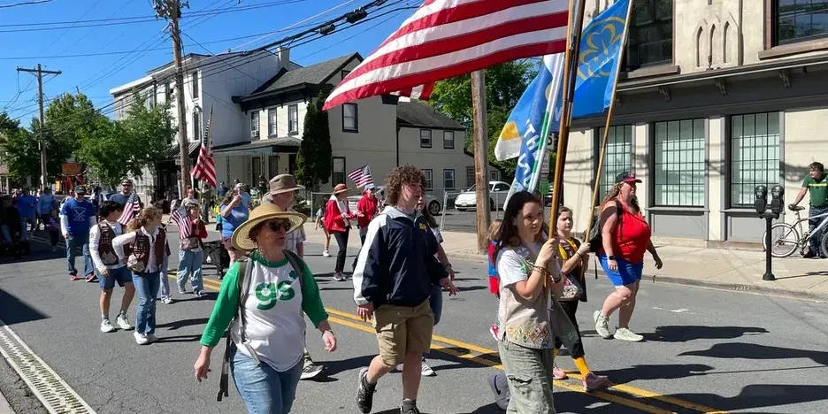 people marching down main street with an american flag