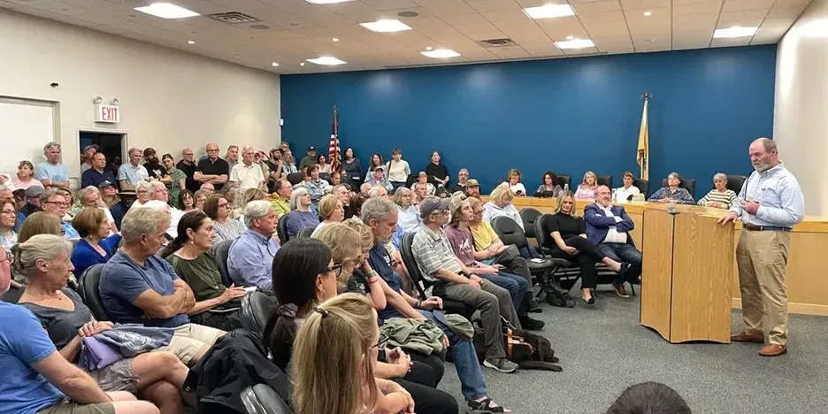 a large crowd listens to John Connors speak