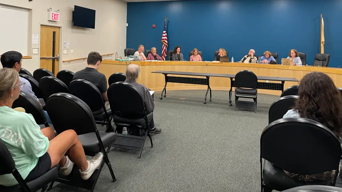a group of commissioners sitting at a dais in front of citizens sitting in chairs