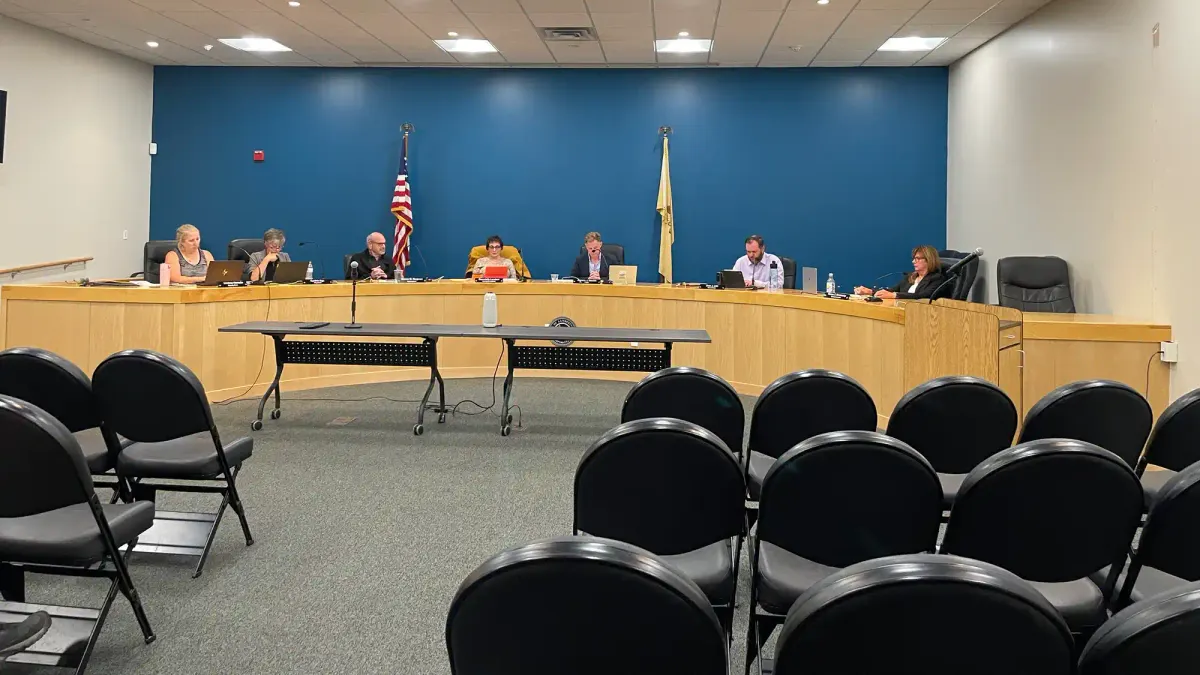 a group of council members sitting in their places behind the dais