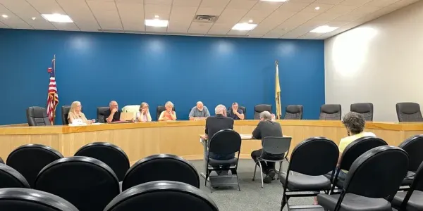 men sitting at a table before the Shade Tree Commission