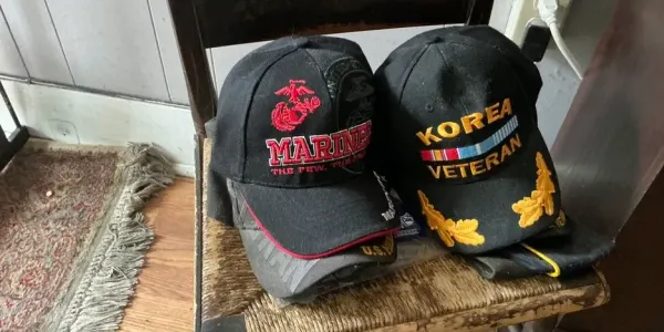 two military veteran hats resting on an old chair