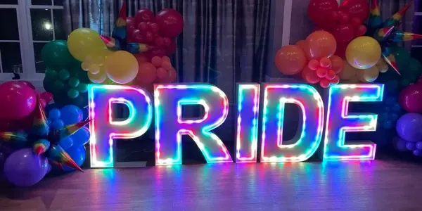a brightly-lit, colorful 3D sign that reads "PRIDE"
