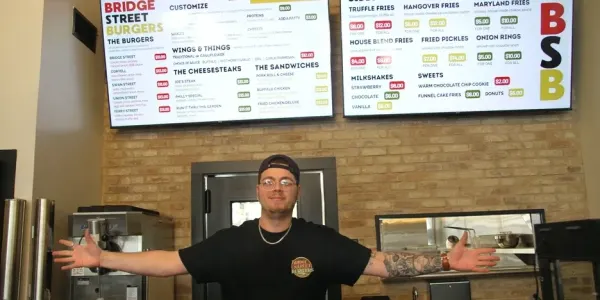 a man stands in front of a fast food menu