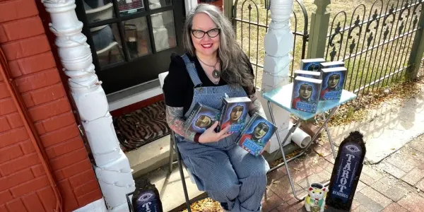 Kristine Gorman sitting and holding a bunch of Tarot decks