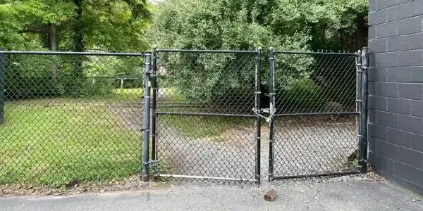 a chain link fence with the gate closed and locked with a chain and padlock