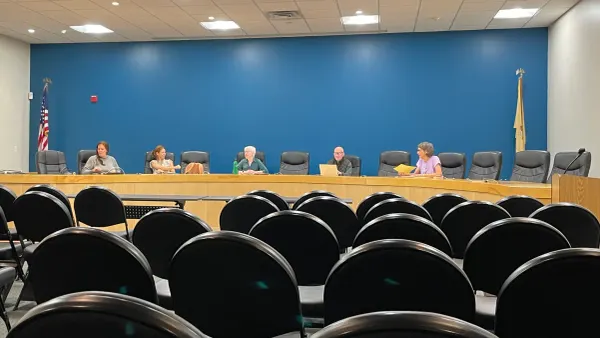 five commission members sitting at the dais