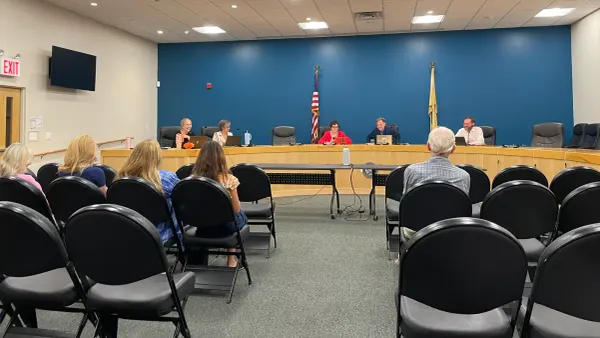 council members sitting at the dais, community members sit in chairs facing them