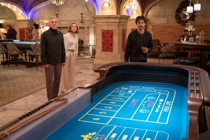 Christoph Waltz, Renée Zelweger, and Logan Lerman peer at a craps table, while Selena Gomez and Martin Short run through the background
