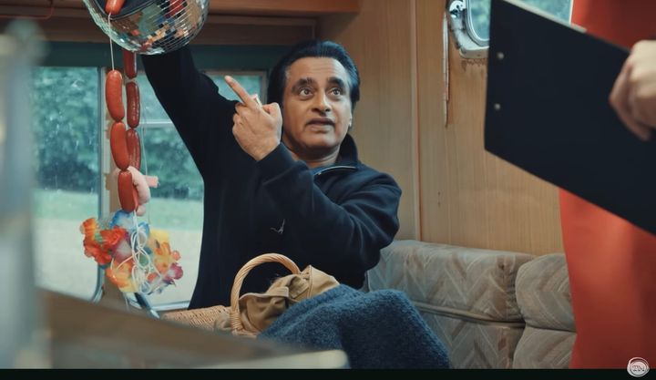 Sanjeev Bhaskar points to a mobile he made using a disco ball and a string of fake sausages.