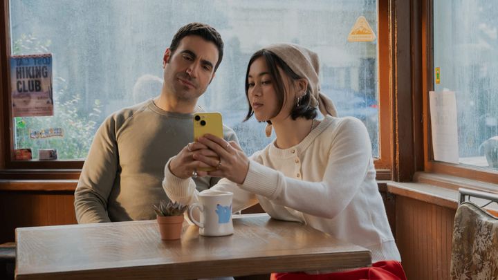 Brett Goldstein and Lukita Maxwell pose for a selfie in a coffee shop
