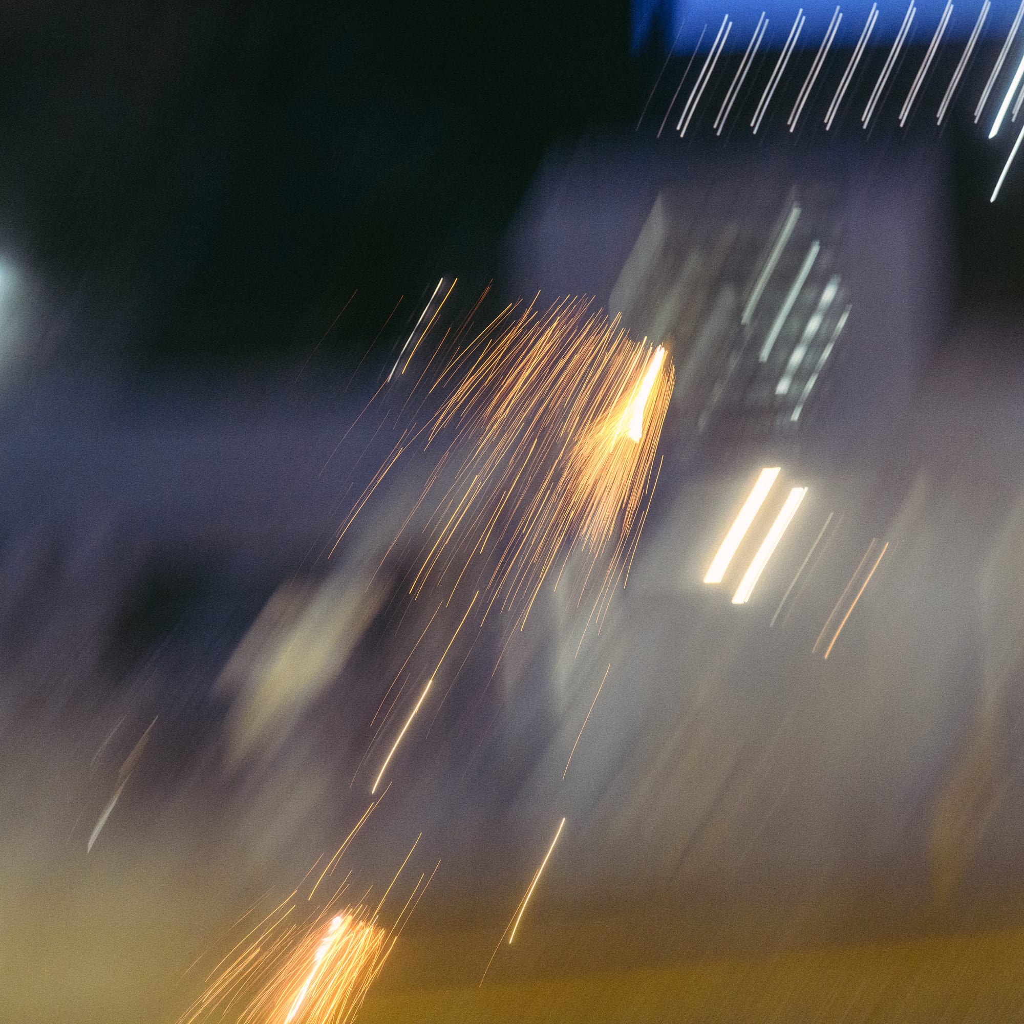 A cloud of smoke and spark from a flying tear gas canister flying in midair