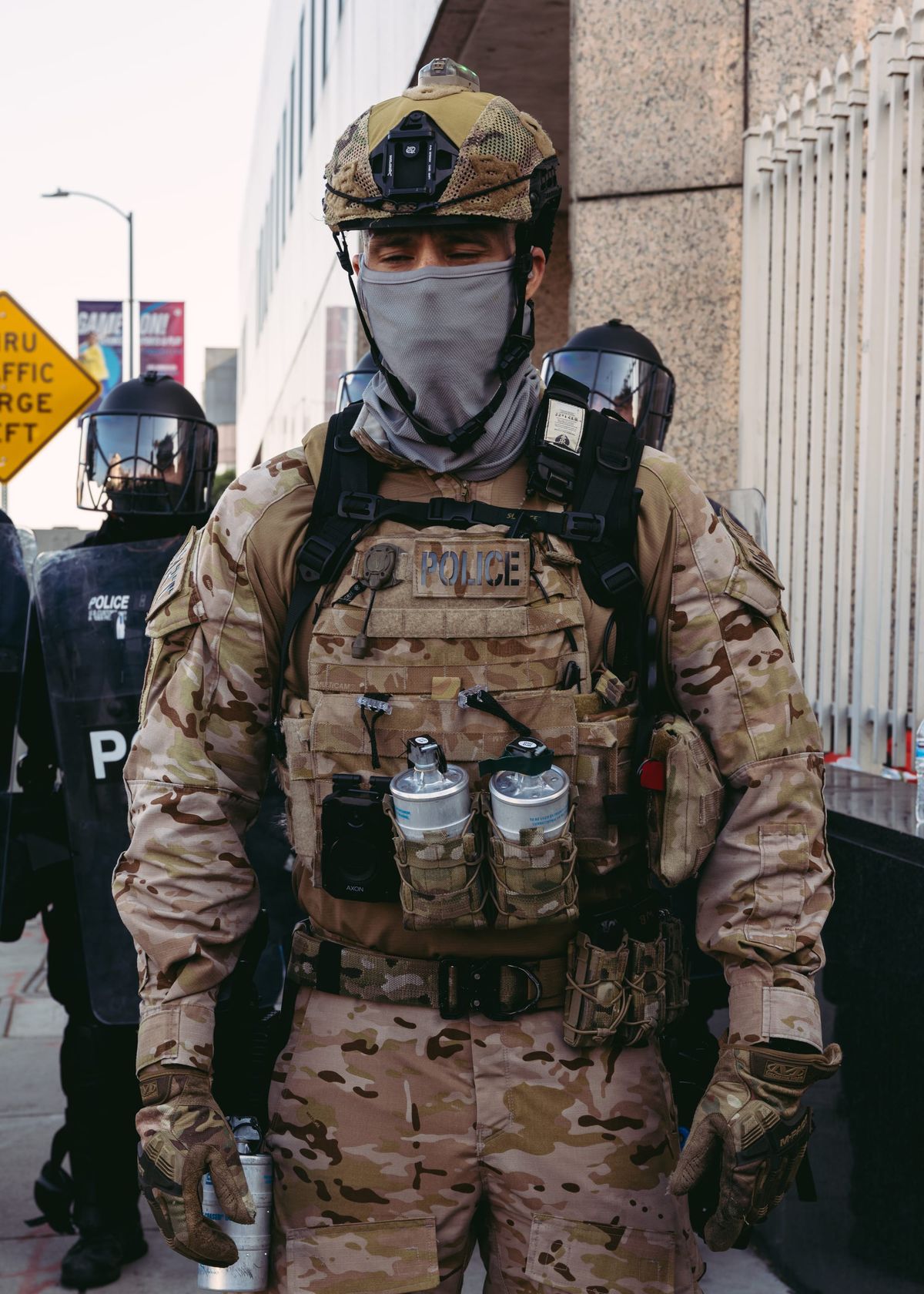 A federal law enforcement officer in military gear stands outside the Metropolitan Detention Center at an anti-ICE rally in downtown LA