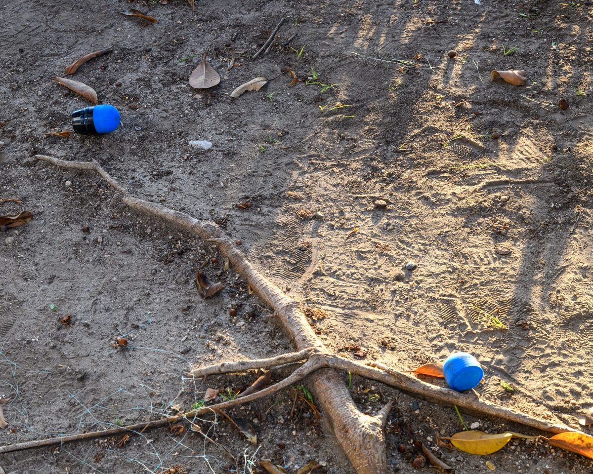 Spent 40mm foam rounds with blue tips lay on the ground
