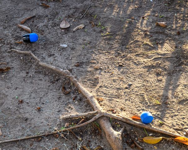 Spent 40mm foam rounds with blue tips lay on the ground