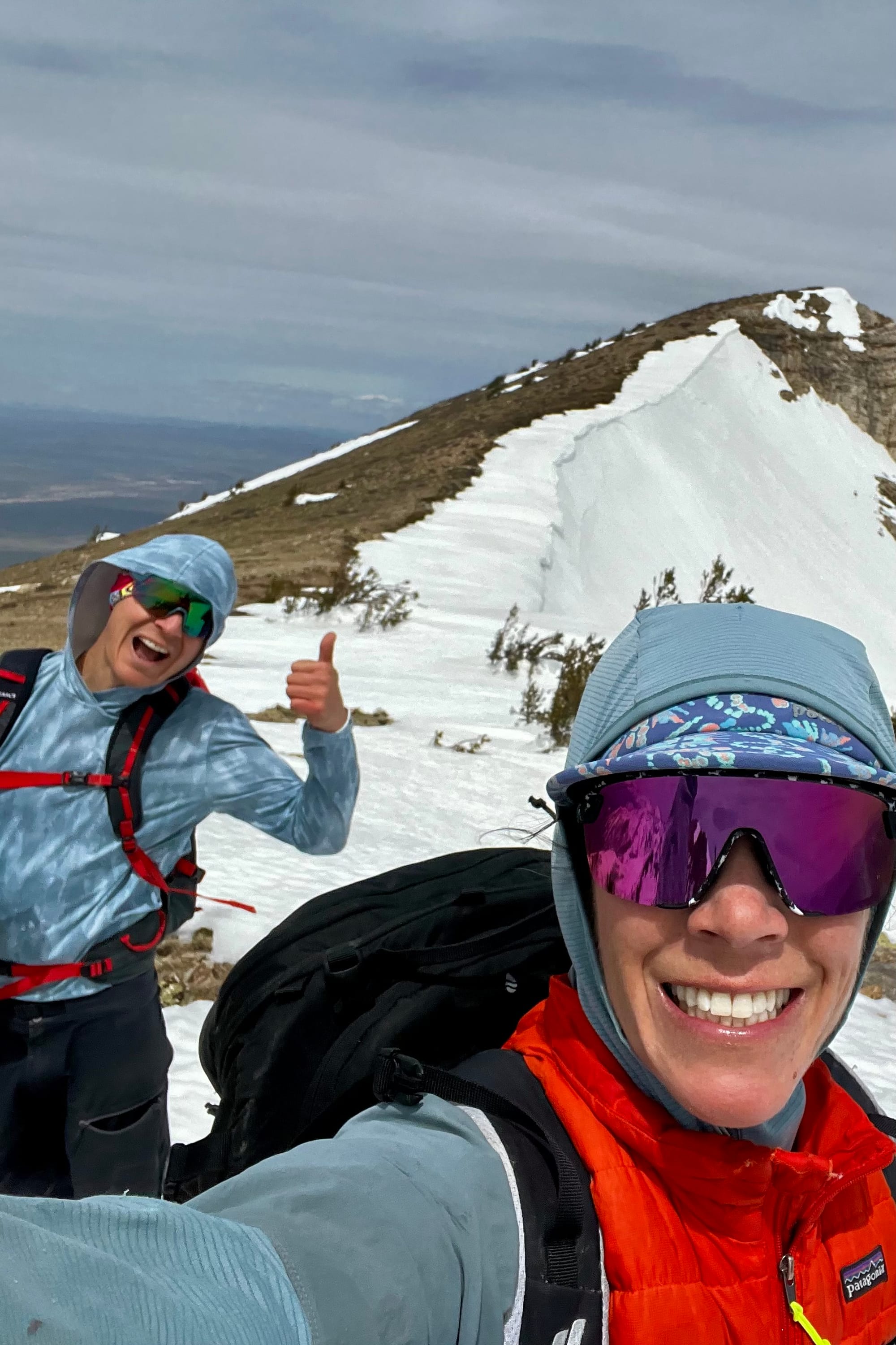 Picture of man and woman in front of snowy ridge on mountain.