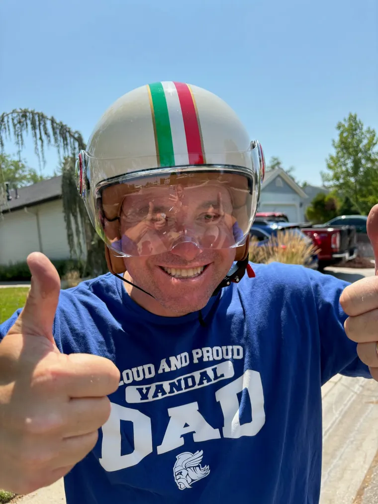 Picture of man in striped motorcycle helmet. 