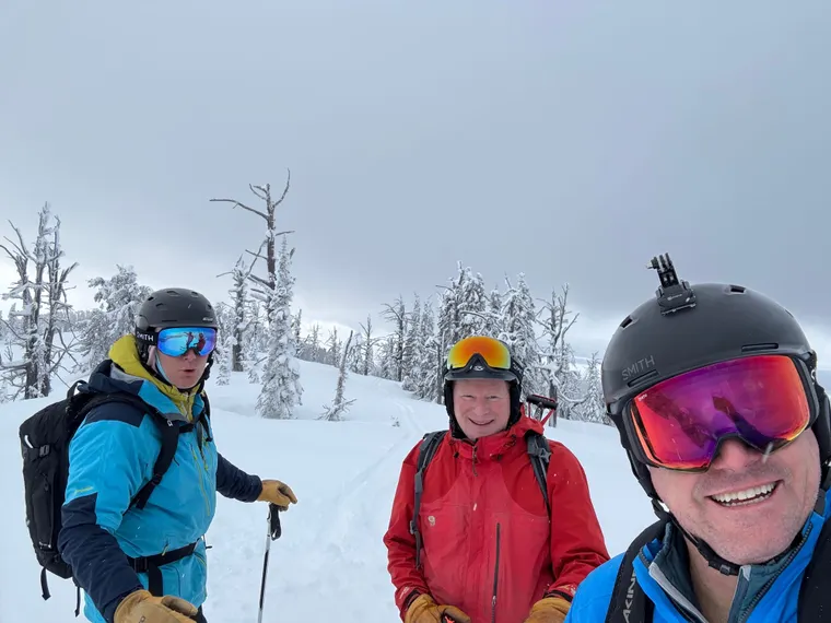 Picture of three guys skiing the trees.