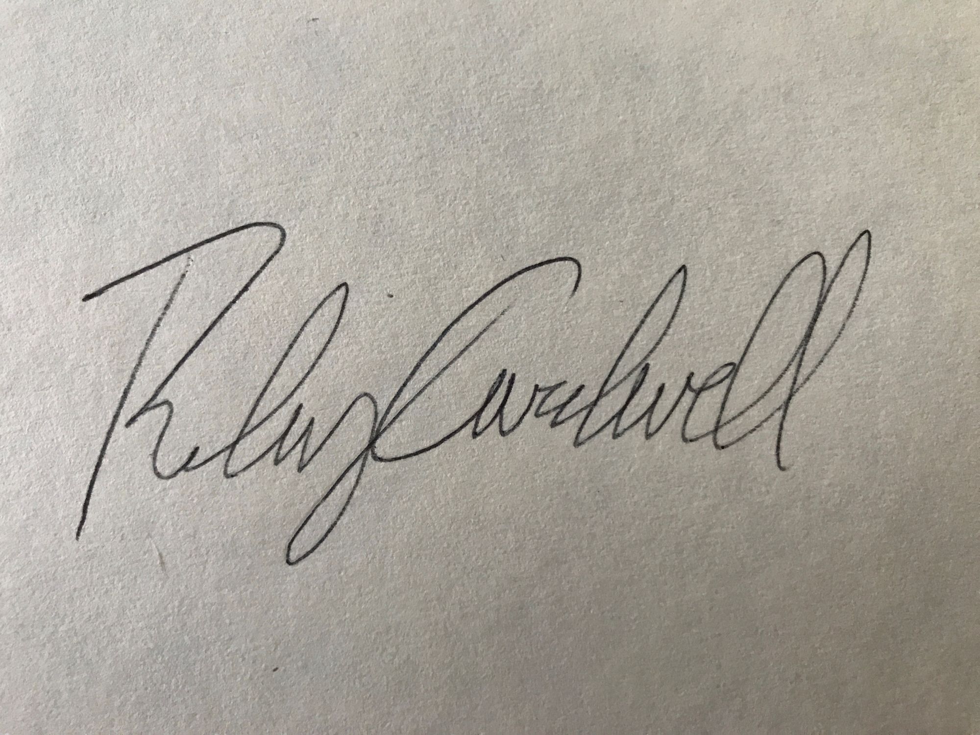 A photo of the author's signature on white paper. 