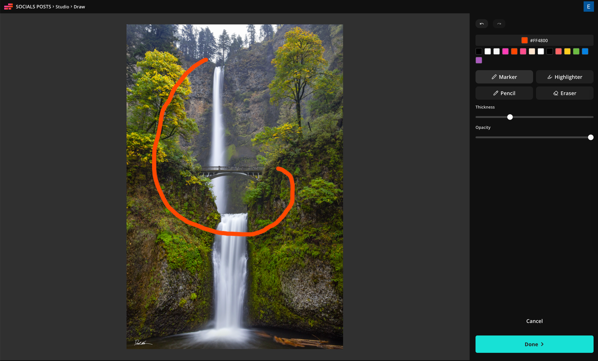 Drawing a red curved drone flight path around a waterfall image using the Draw tool in Kapwing.