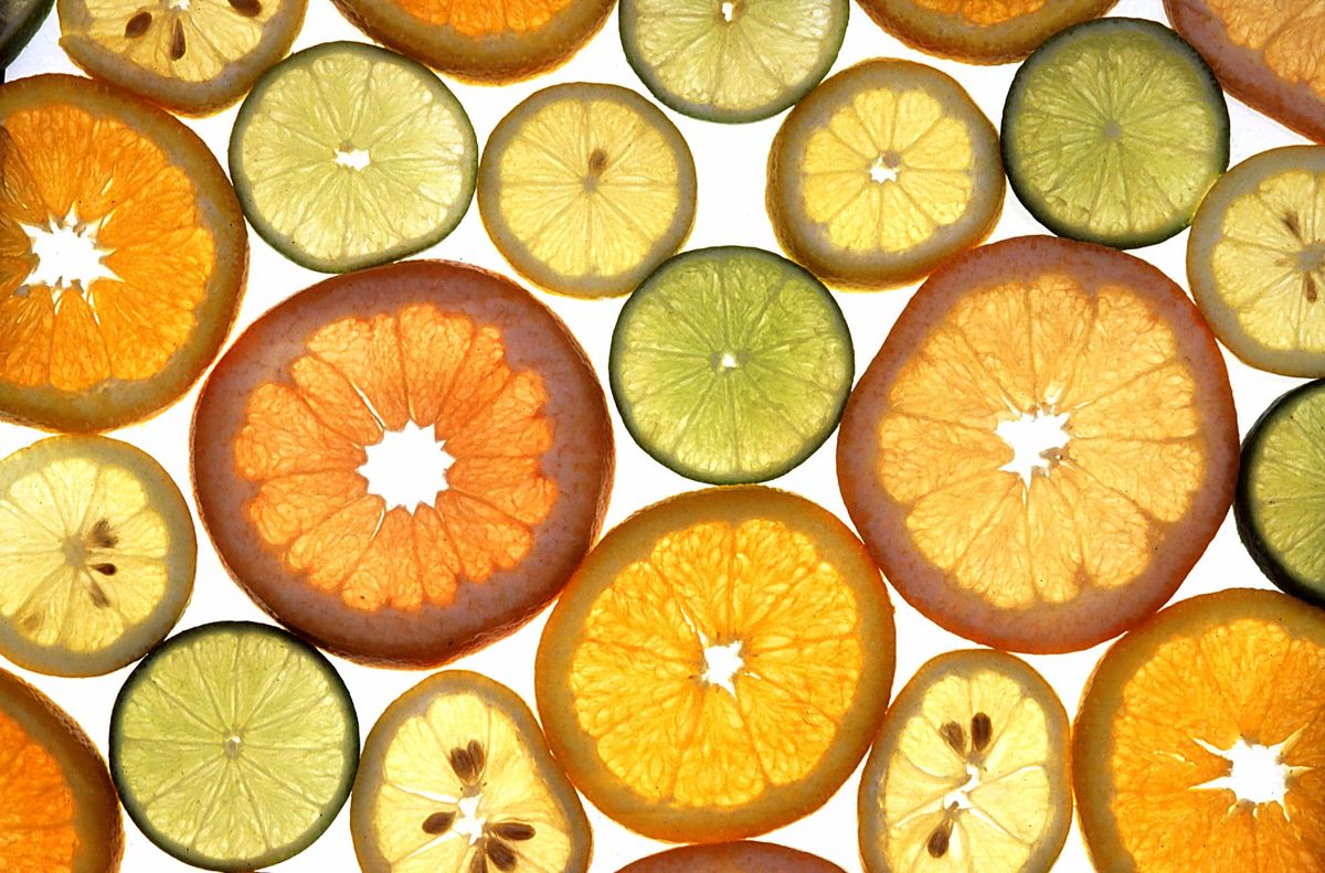 Slices of assorted citrus fruit on a white background.