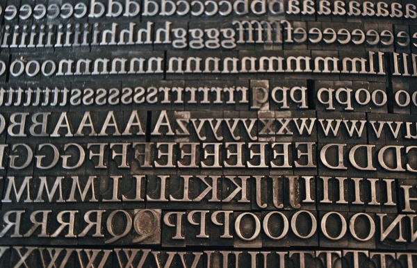Full-screen image of letterpress type, showing both upper-case and lower-case letters.
