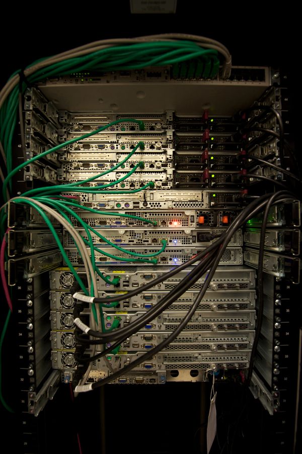 Photo of computer servers in a rack. The photo has a dark background, but the servers are well-lit, making them stand out.