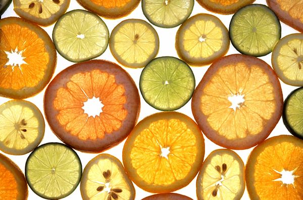 Slices of assorted citrus fruit on a white background.