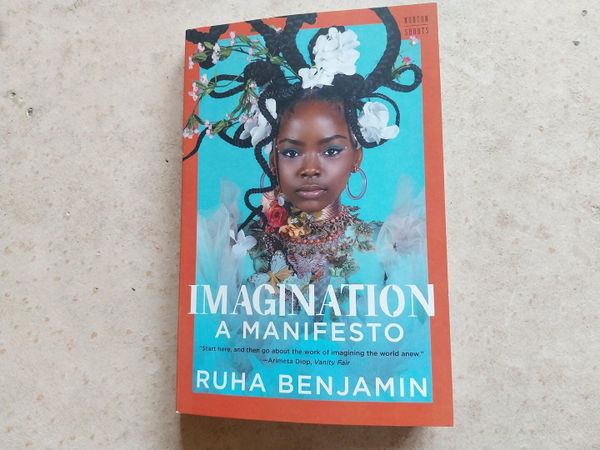 A book photographed against a concrete background. The book is Ruha Benjamin's "Imagination: A Manifesto."