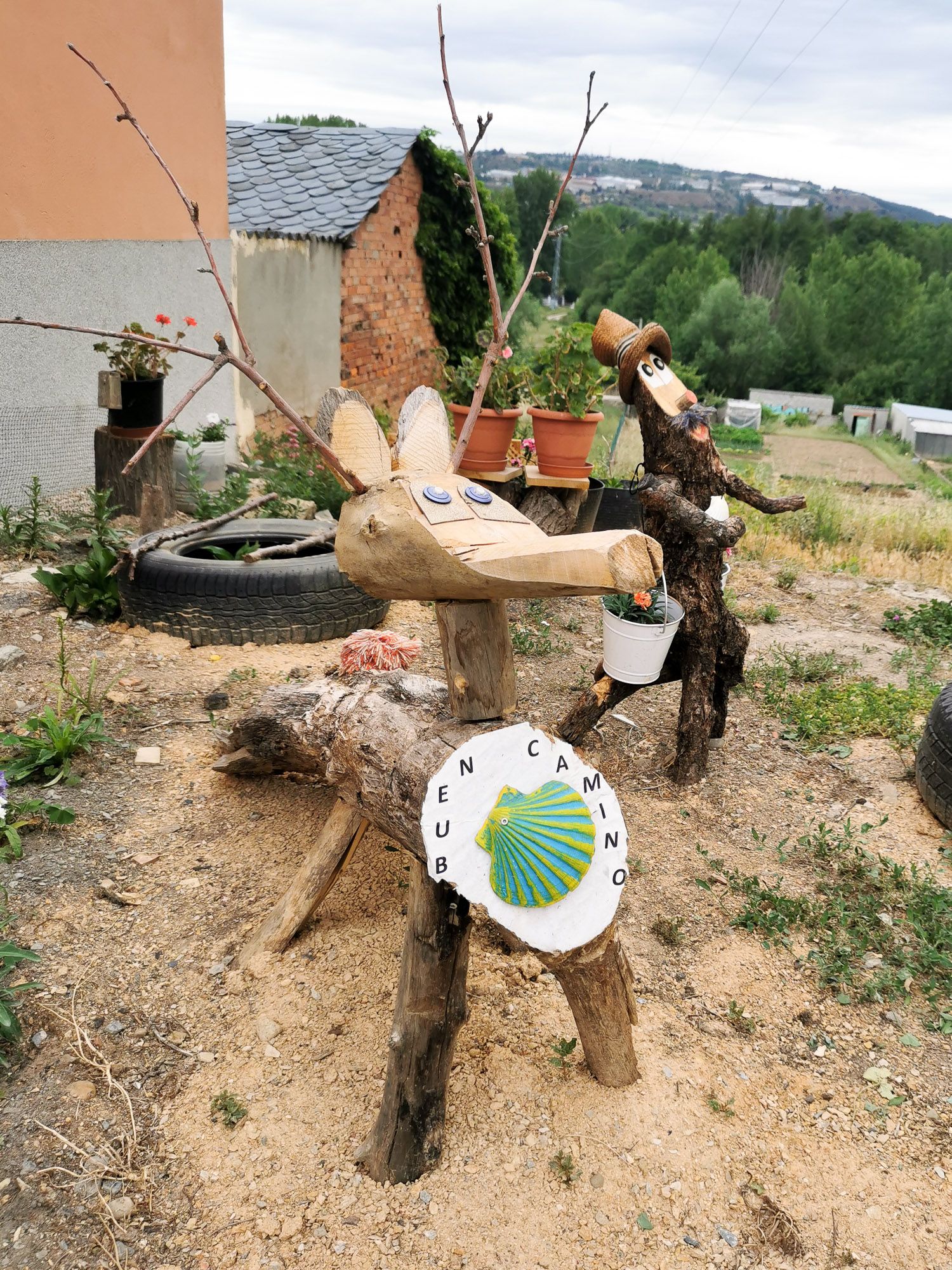 ไม้แกะสลักแบบง่าย ๆ เป็นรูปกวาง และลิง มีคำว่า Buen Camino ไว้ทักทาย Pilgrim ที่เดินผ่าน