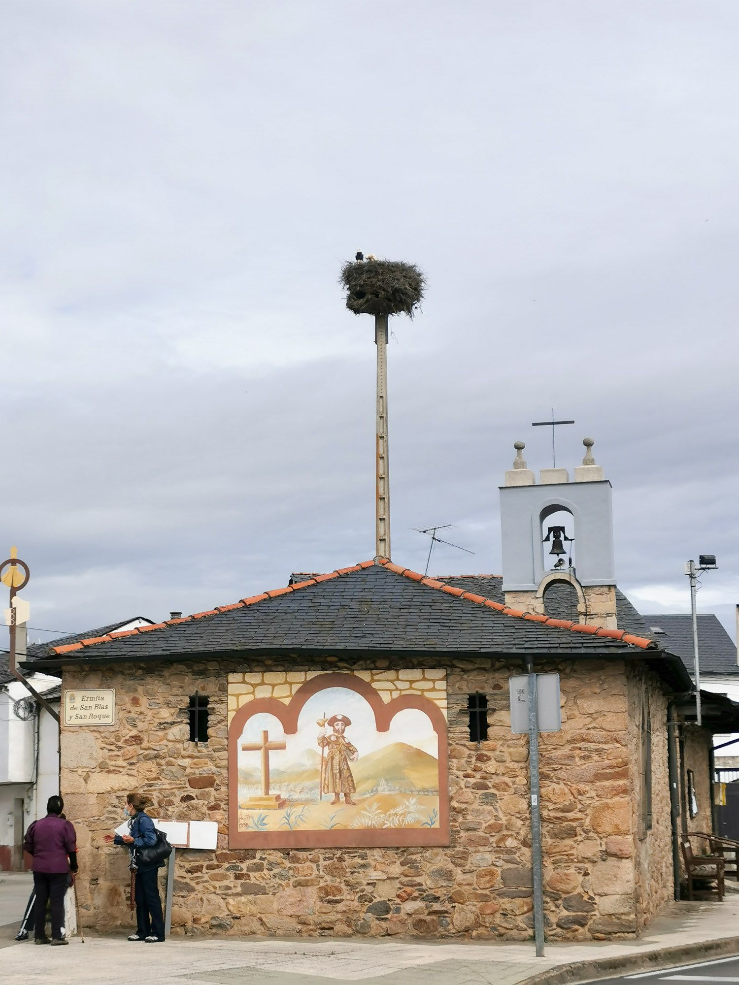 โบสถ์เล็ก ๆ มีรูปเซนต์เจมส์ถือไม้เท้าอยู่หน้าโบสถ์ ยอดโบสถ์มีรังนกระสาขาว พร้อมด้วยนกสองตัวอยู่ในนั้น