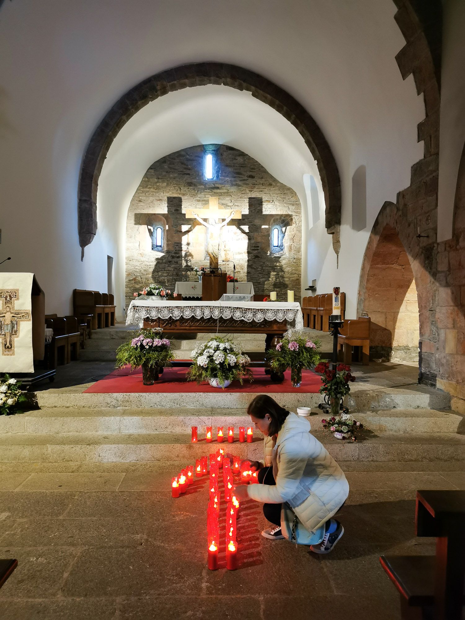 Pilgrim จัดเทียนสีแดงที่วางบนพื้นหน้า Altar เป็นรูปลูกศร สัญลักษณ์อีกอันหนึ่งของ Camino