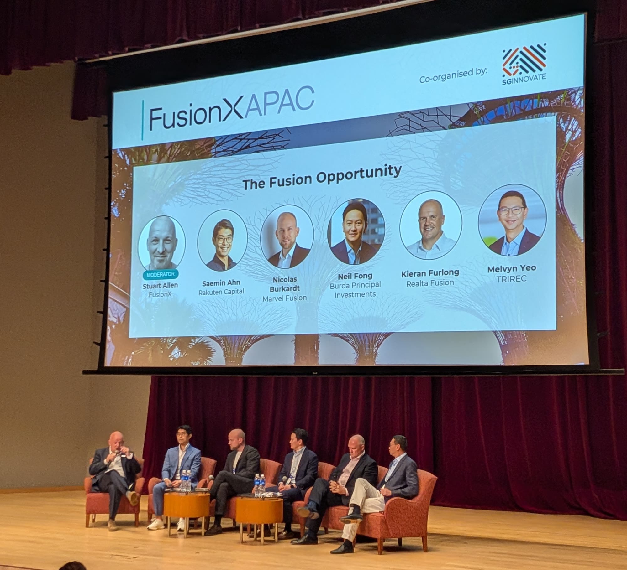 The Fusion Opportunity panel on stage at FusionX:APAC 2026 in Singapore: Stuart Allen of FusionX moderating Saemin Ahn, Nicolas Burkardt, Neil Fong, Kieran Furlong and Melvyn Yeo