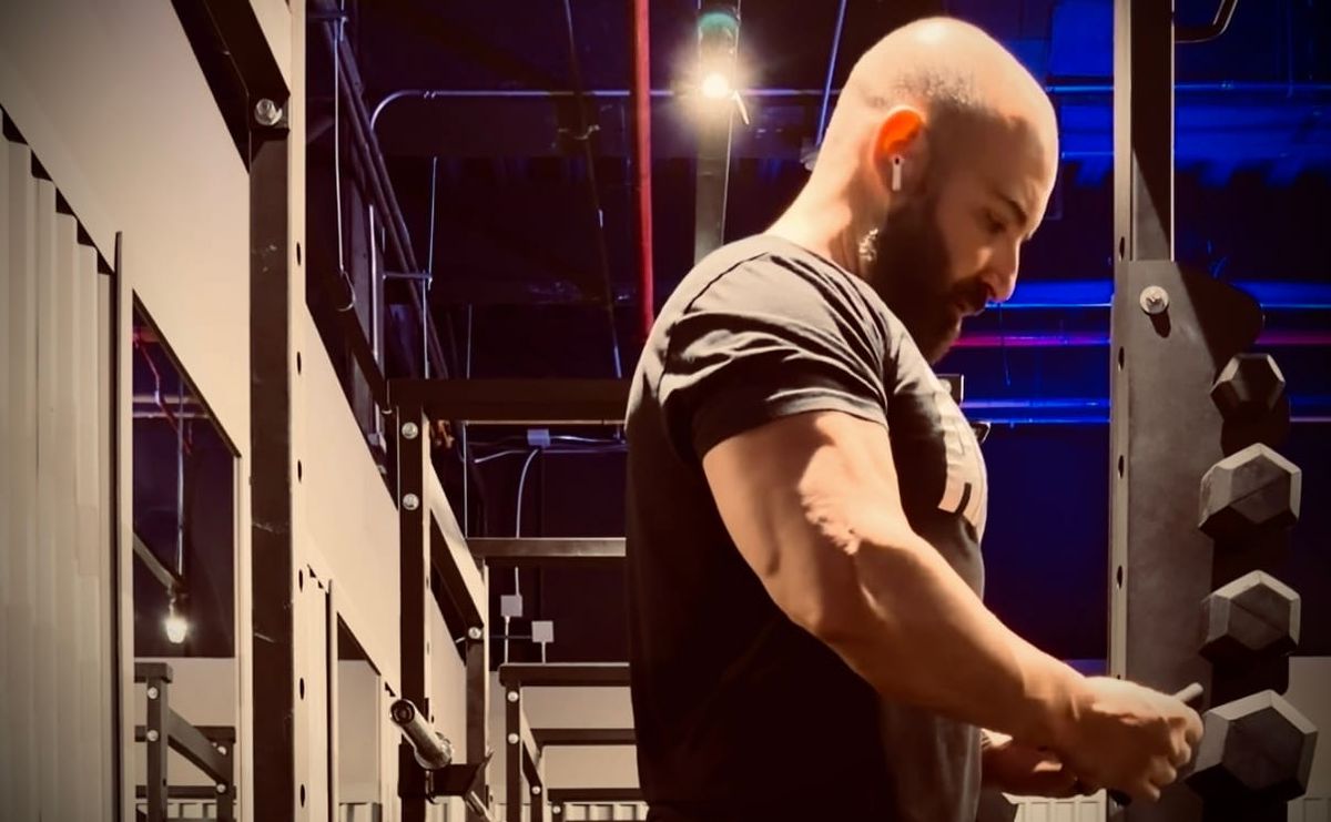 Vanja Petreski preparing for barbell rows, with his right arm in focus