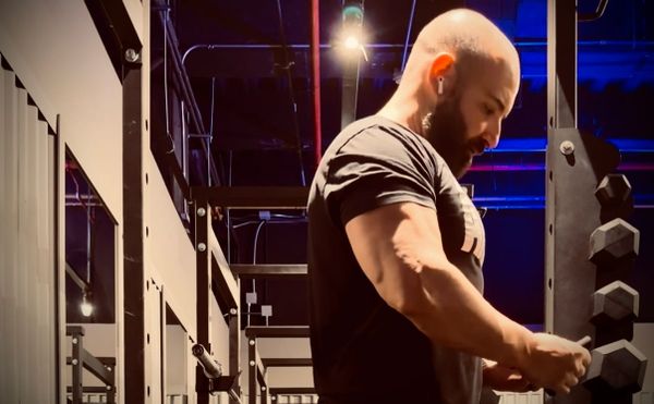 Vanja Petreski preparing for barbell rows, with his right arm in focus
