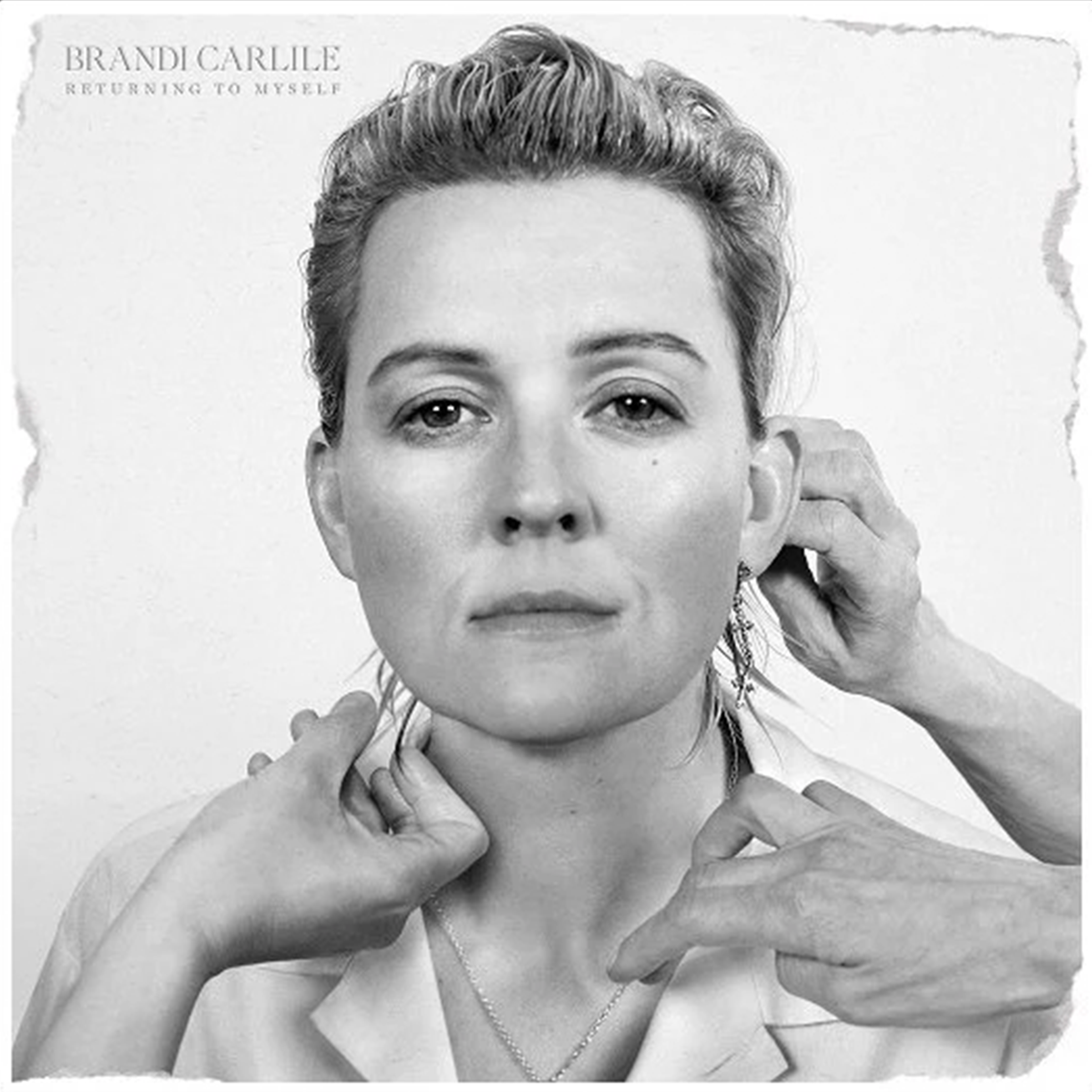 The cover of Brandi Carlile's "Returning to Myself" depicting the singer in black and white with hands preparing her for the photoshoot.