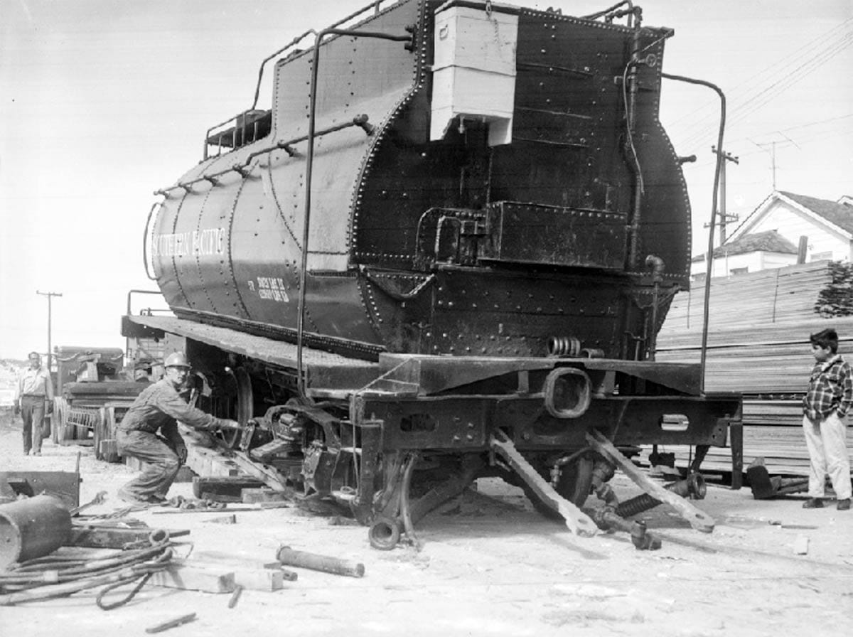 Tender of engine #1294 being winched onto truck.