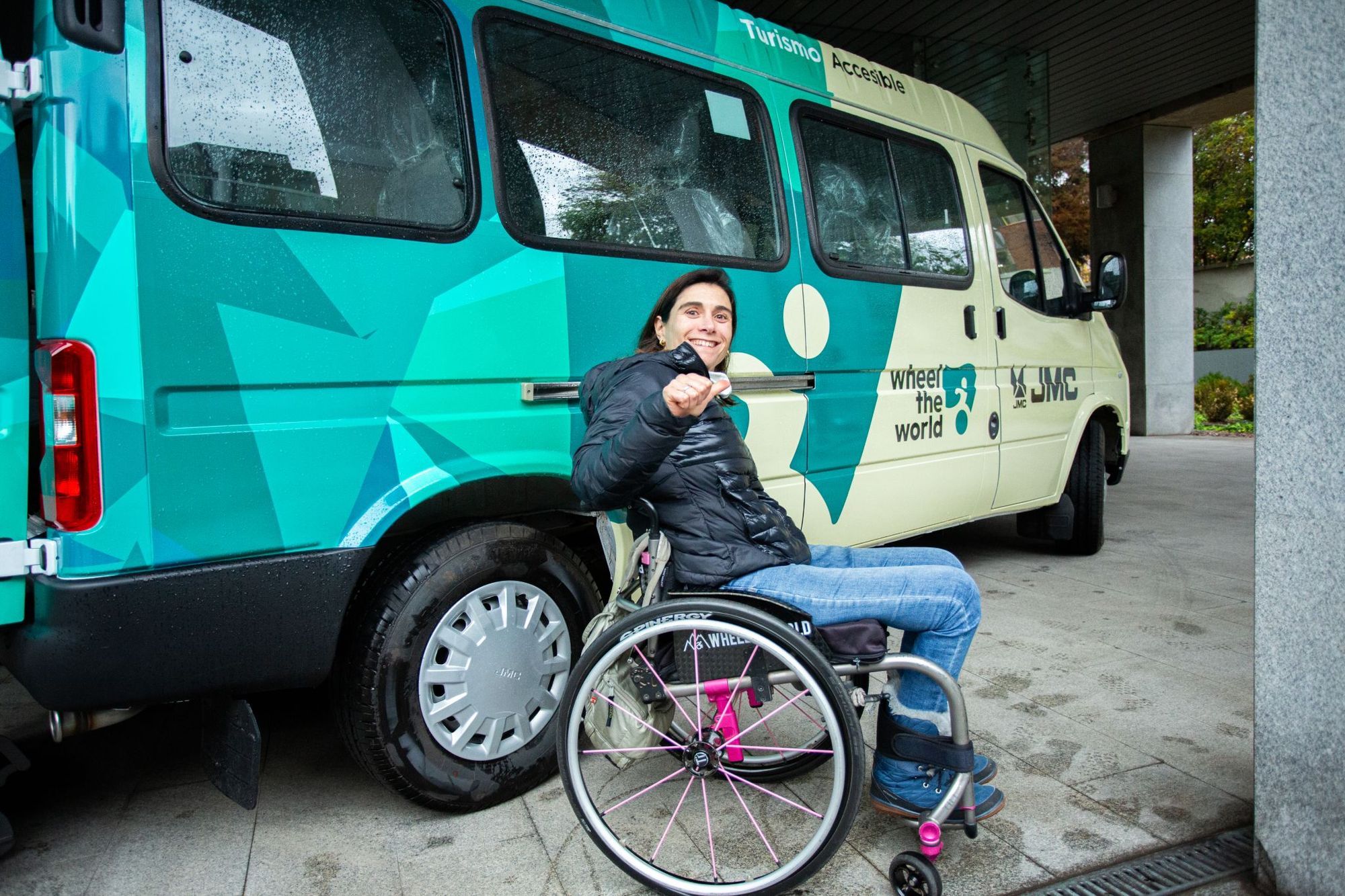 Wheelchair-user in front of an accessible van