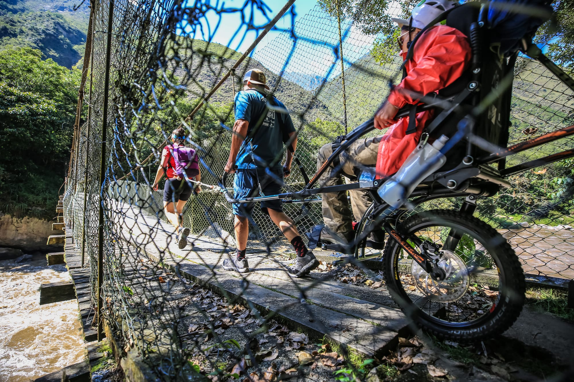 Wheelchair user and guide on the Inca Trail bridge, highlighting accessible travel you can book through Wheel the World