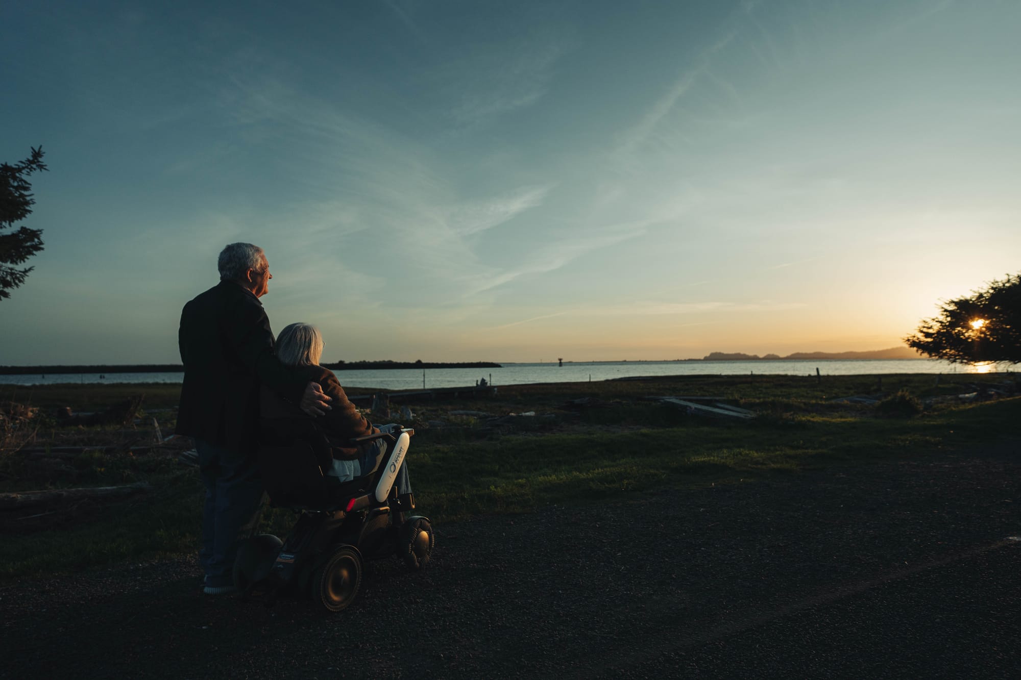 Sunset over the ocean. Wheelchair user and partner on an accessible trip with Wheel the World