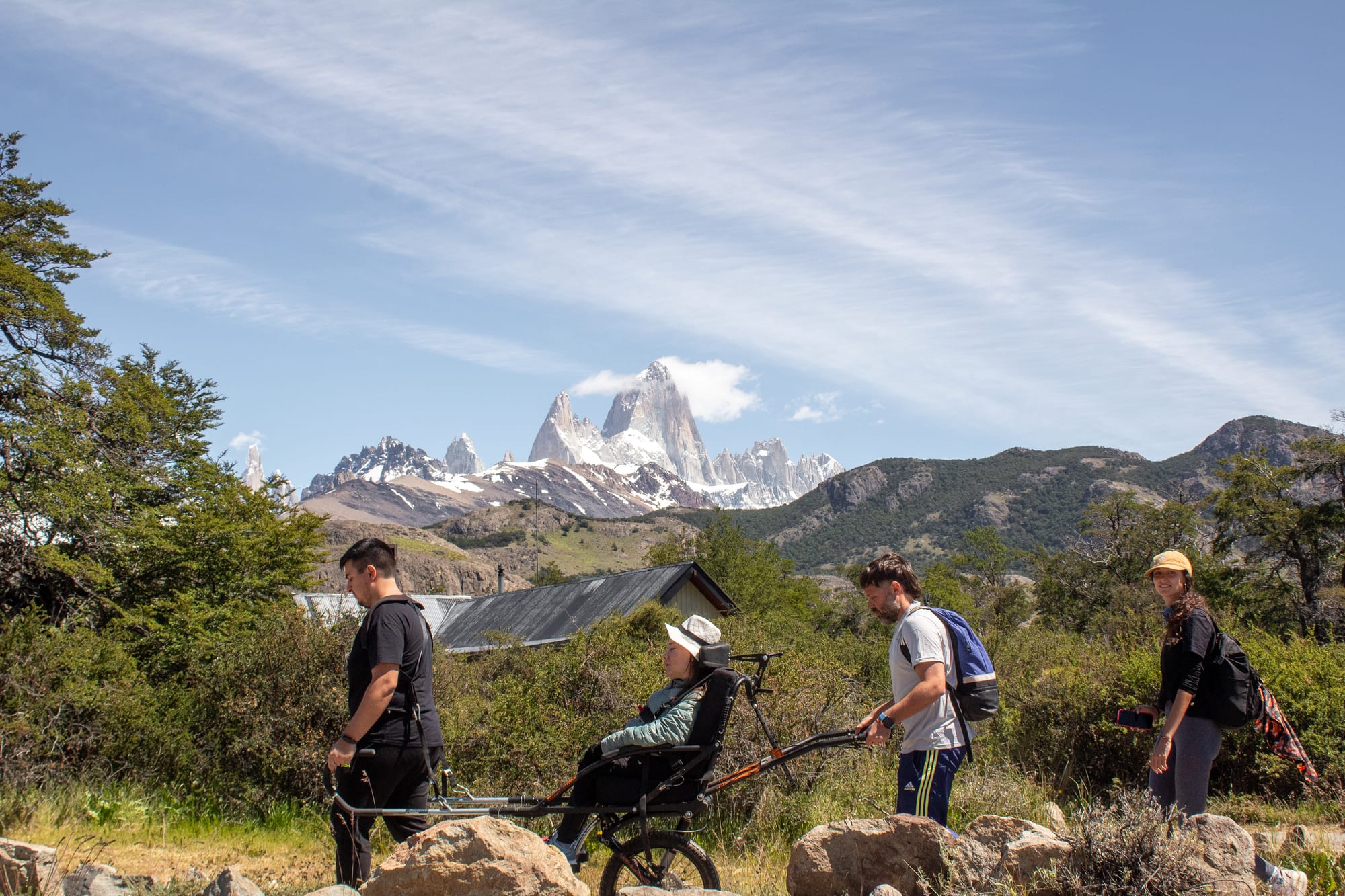 Hiking Patagonia with a joelette wheelchair and assistance from people