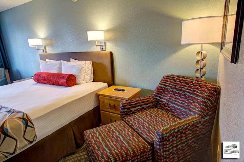 Bed and lounge chair in bedroom at Old Town Inn in Florence, Oregon