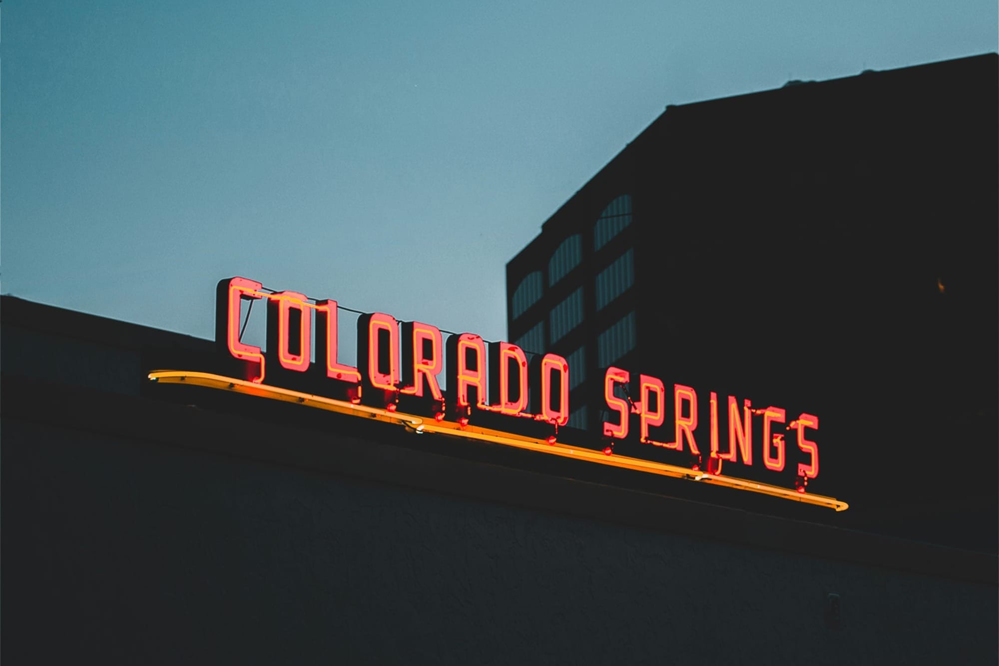 Neon sign at dusk that says "Colorado Springs"